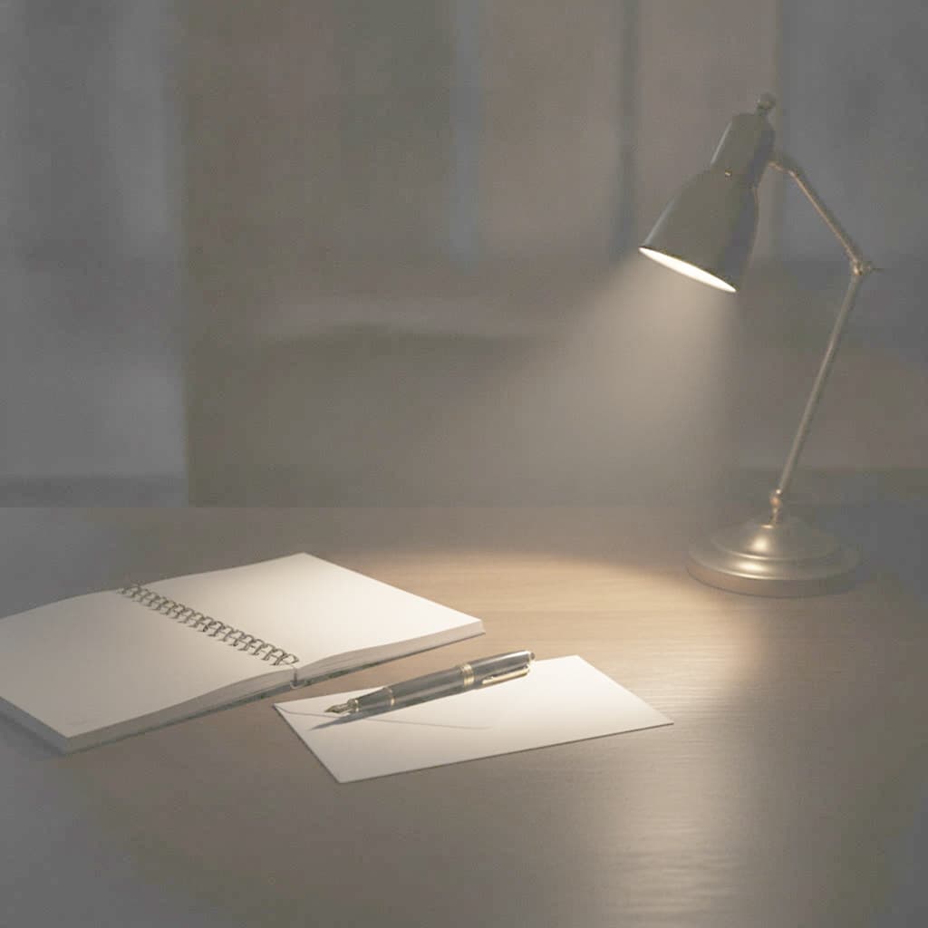 Schreibtisch mit Notizbuch, Füllfederhalter und einer Lampe